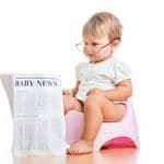 funny child girl reading newspaper on chamberpot